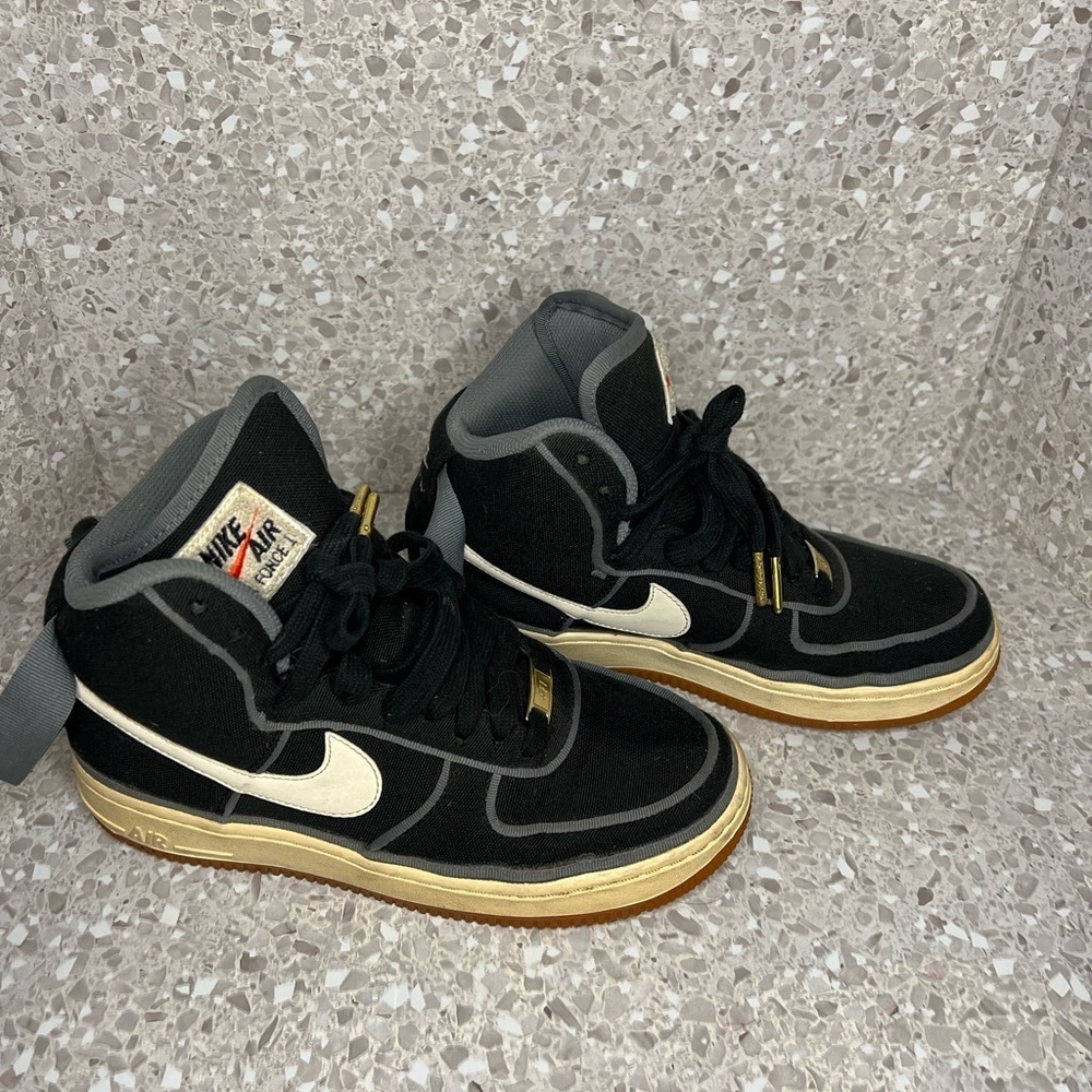 Nike Air Force 1 in Black Canvas. Gold Accents on laces.